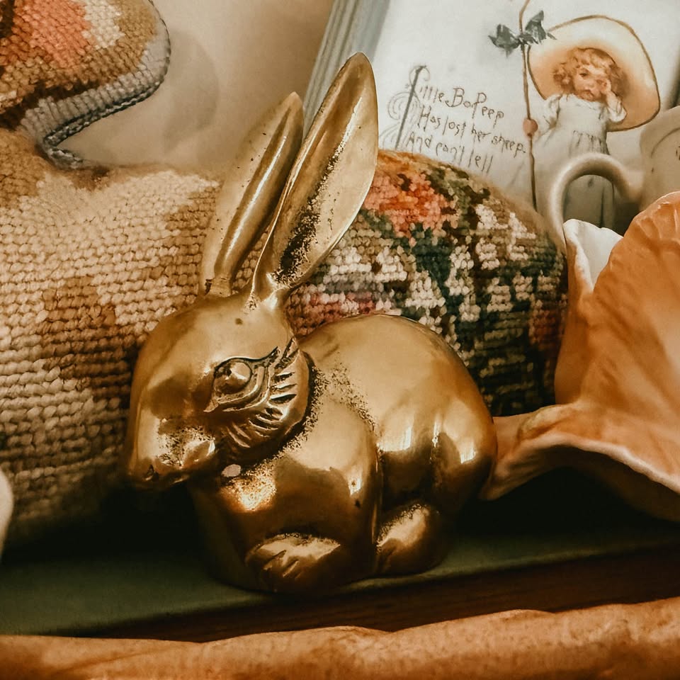 Vintage solid brass bunny rabbit figurine with long upright ears resting on a shelf