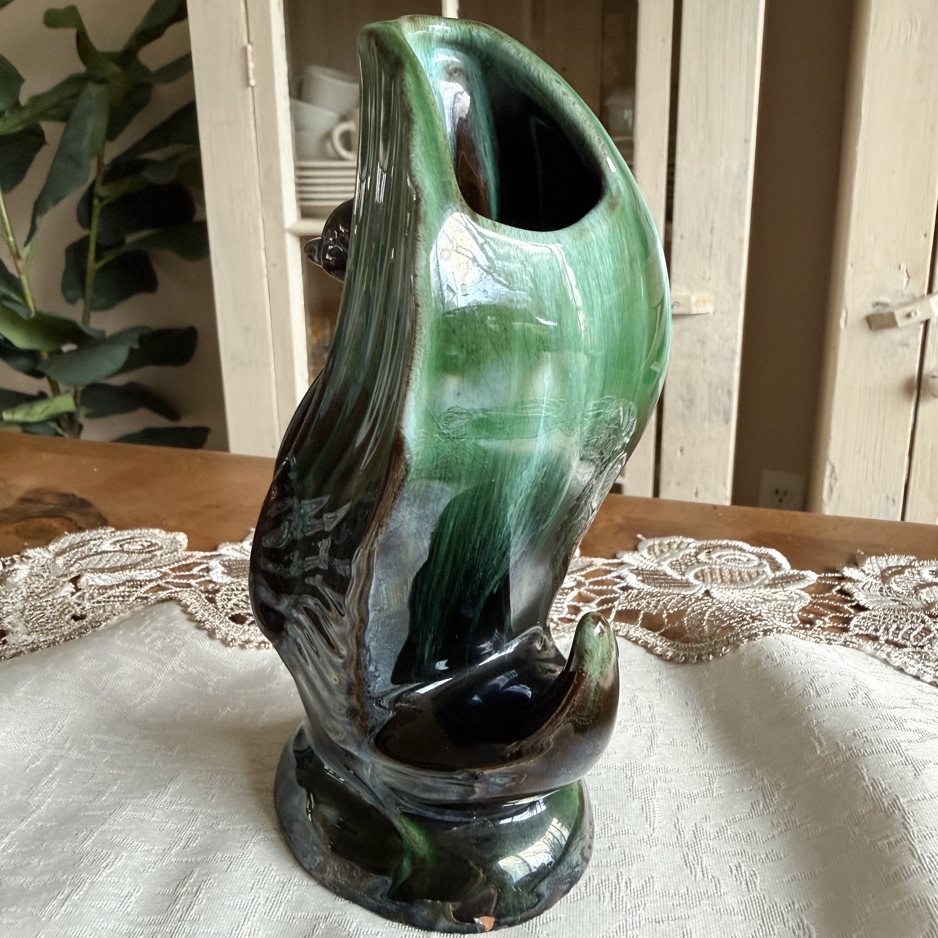 Front-slanted view showing the internal opening of the swan vase and flowing green glaze