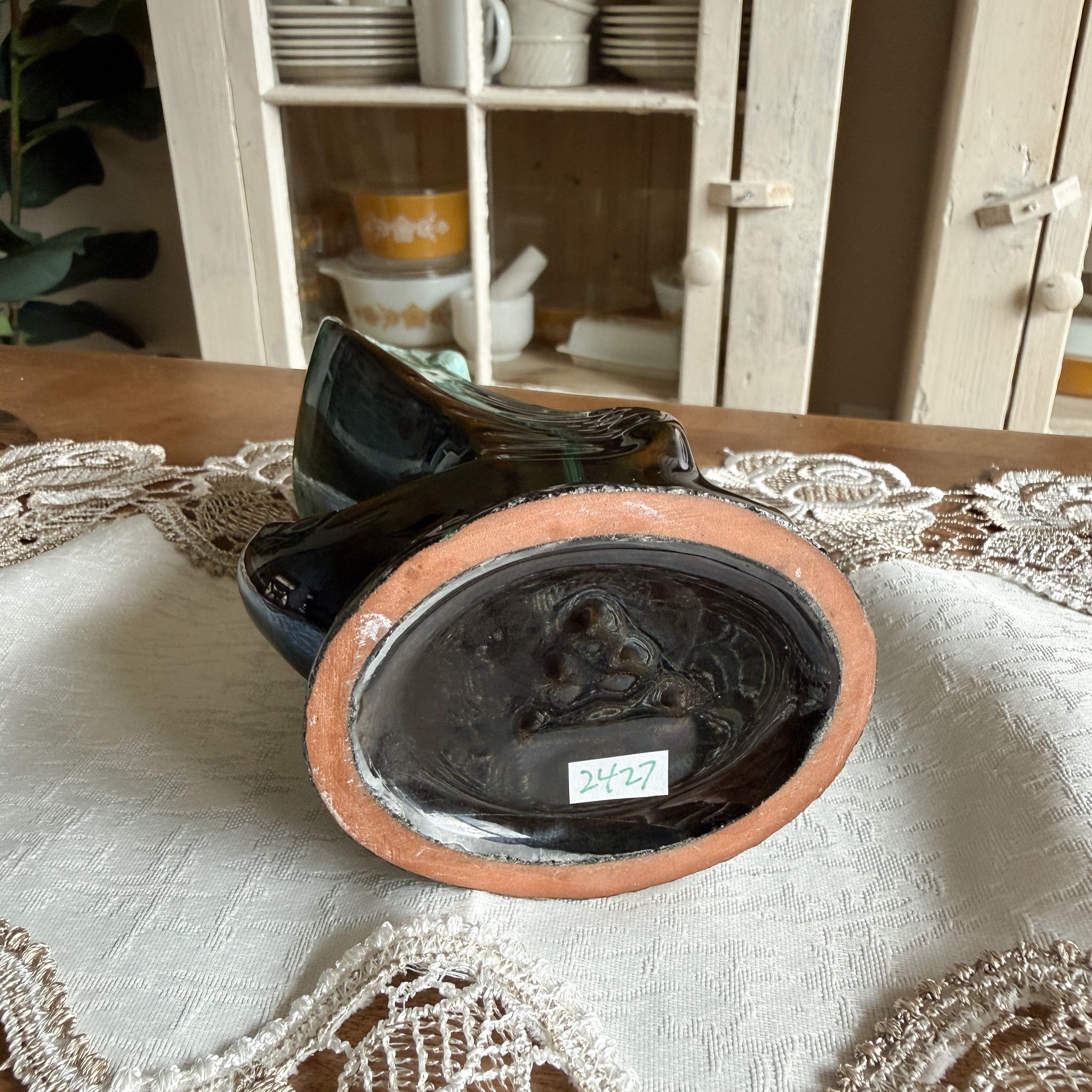 Bottom view of the ceramic vase showing the unglazed orange clay rim 
