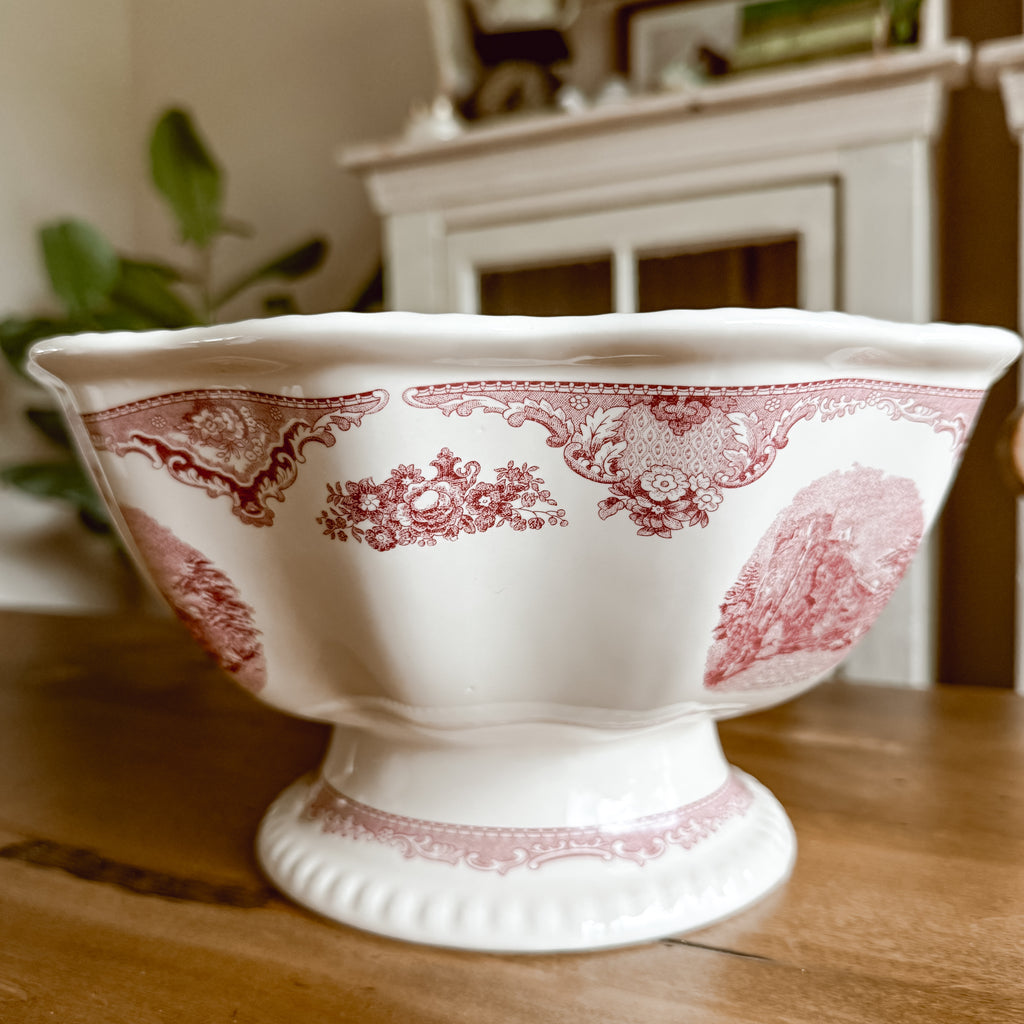 Side view of Johnson Brothers Old Britain Castles pink pedestal fruit bowl highlighting the footed base and wavy rim detail