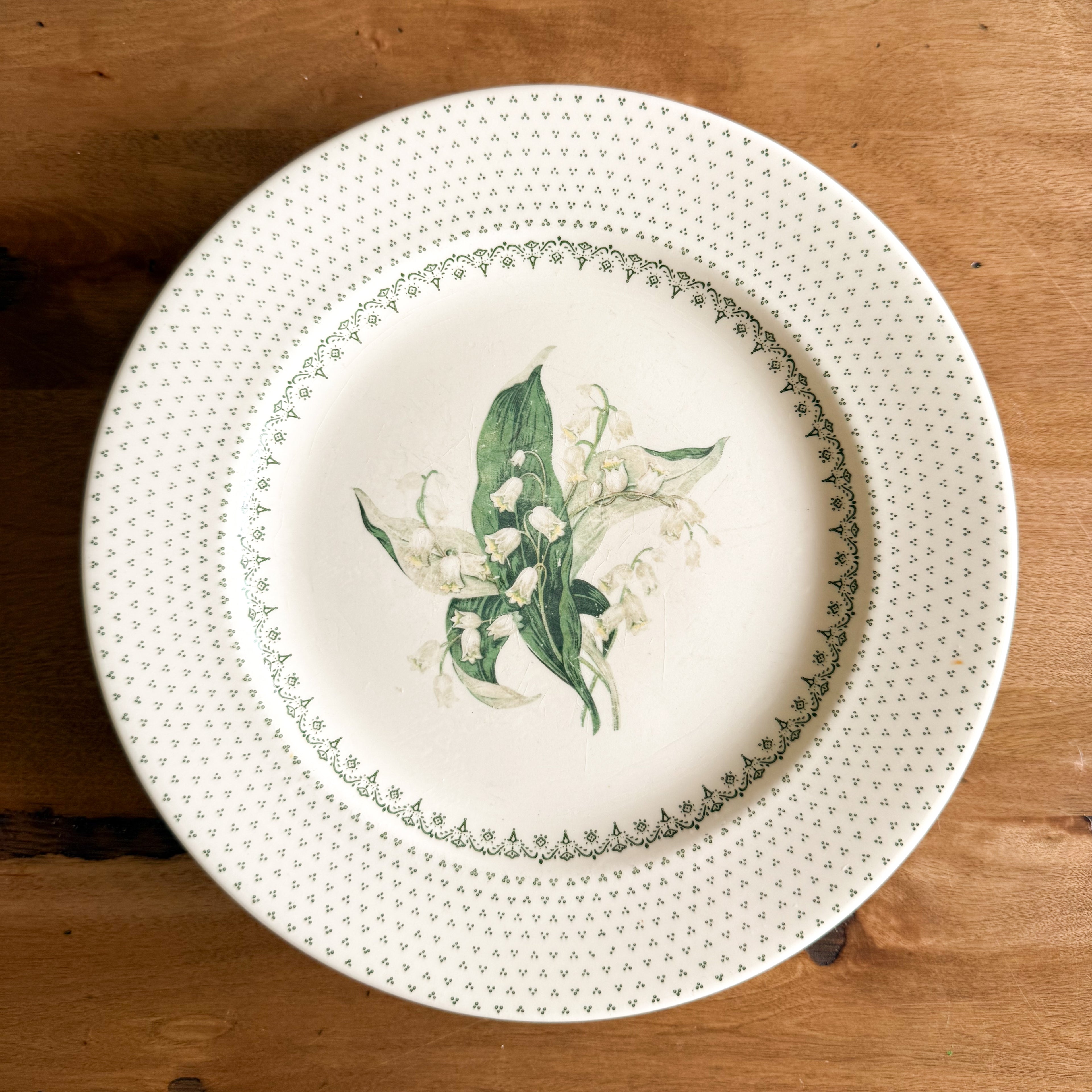 Front view of a single Royal China Waverly dinner plate showing the Lily of the Valley floral center and green geometric filigree border