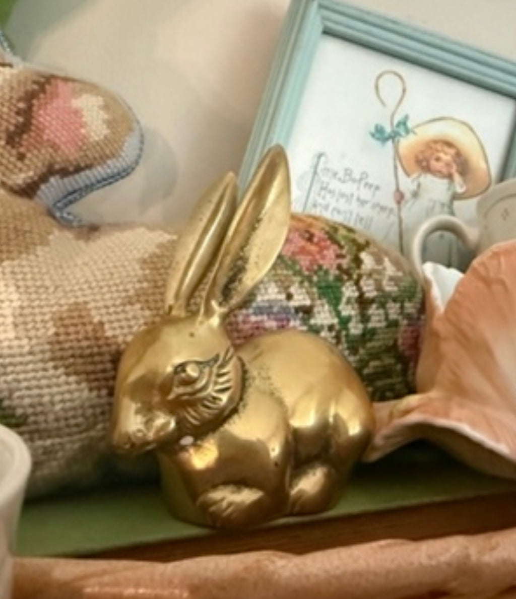 Vintage solid brass bunny rabbit figurine with long upright ears resting on a shelf