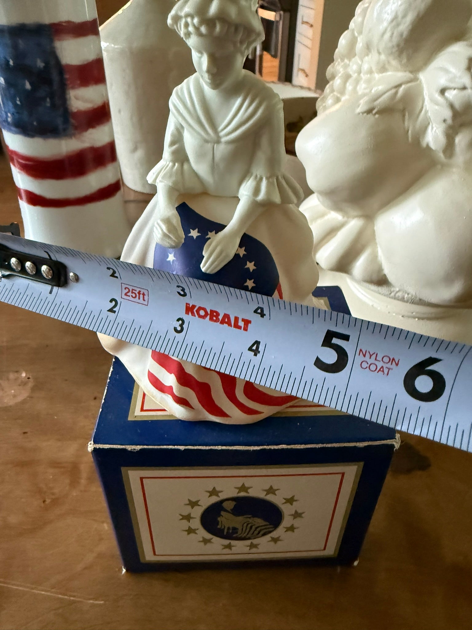 Close-up of a 1970s Avon Betsy Ross matte white glass decanter featuring hand-painted details and colonial dress.