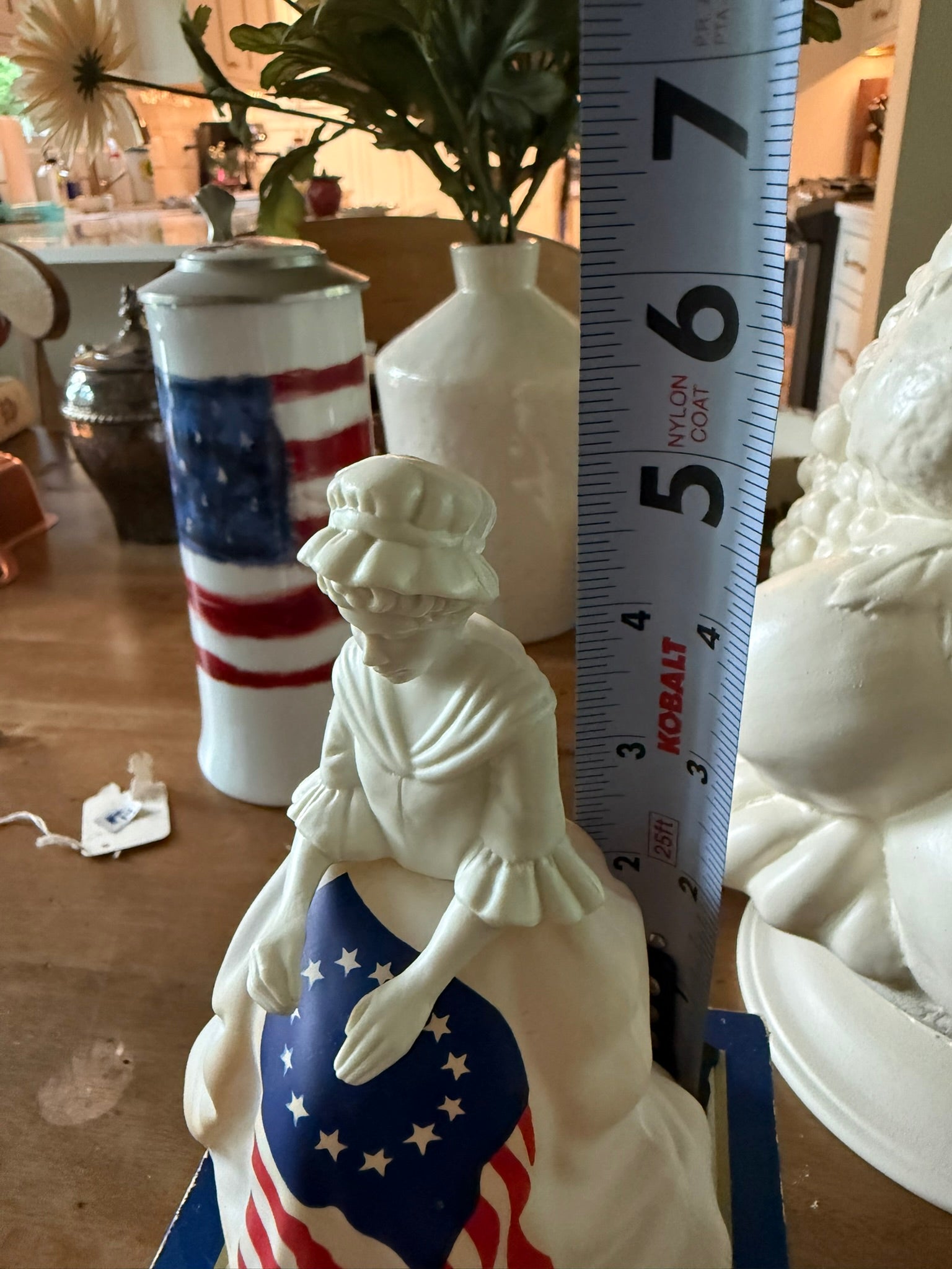 Close-up of a 1970s Avon Betsy Ross matte white glass decanter featuring hand-painted details and colonial dress.