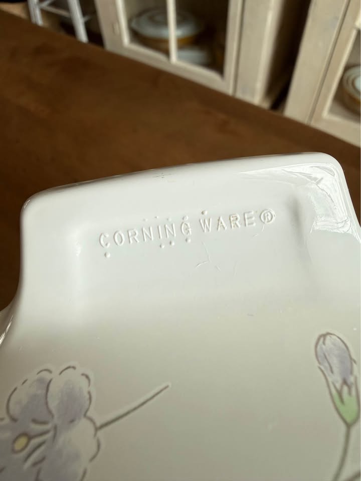 Vintage square CorningWare 1-liter casserole dish in the Pastel Bouquet pattern featuring pink and blue floral illustrations on a white background