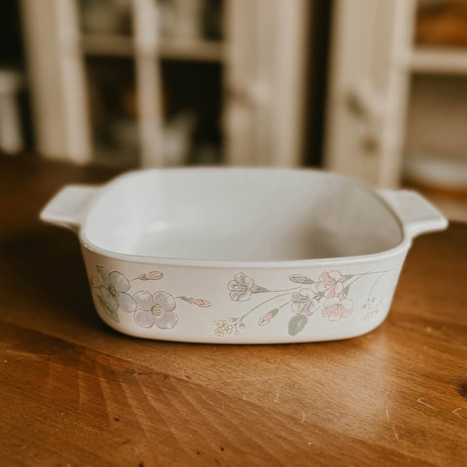 Vintage square CorningWare 1-liter casserole dish in the Pastel Bouquet pattern featuring pink and blue floral illustrations on a white background