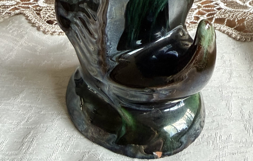 Close-up of the base and tail section, showing the intricate glaze details and a small chip near the bottom.